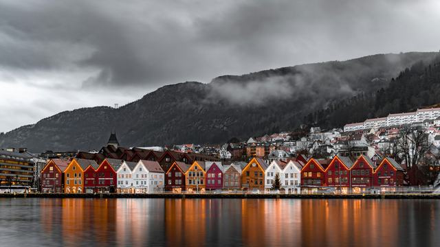 De färgglada husen på Bryggen i Bergen speglade i hamnen