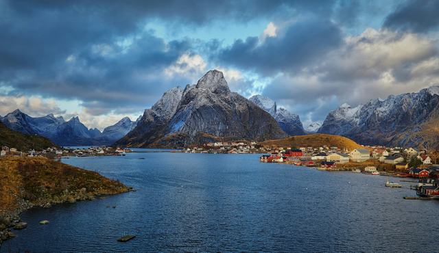 Reine i Lofoten med husen vid vattnet och spetsiga berg i bakgrunden